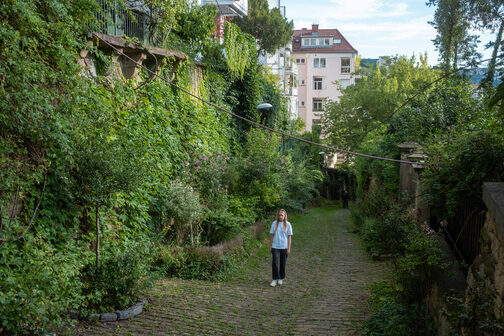 Ein Mädchen läut auf einem Weg, der von Grün umgeben ist.