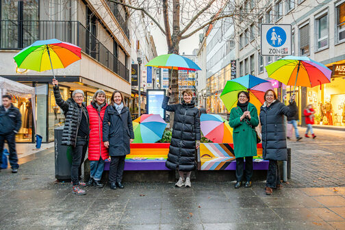 Eine bunte Regenbogenbank in der Stuttgarter Einkaufsstraße, Bürgermeister Sußmann mit lachenden Menschen.